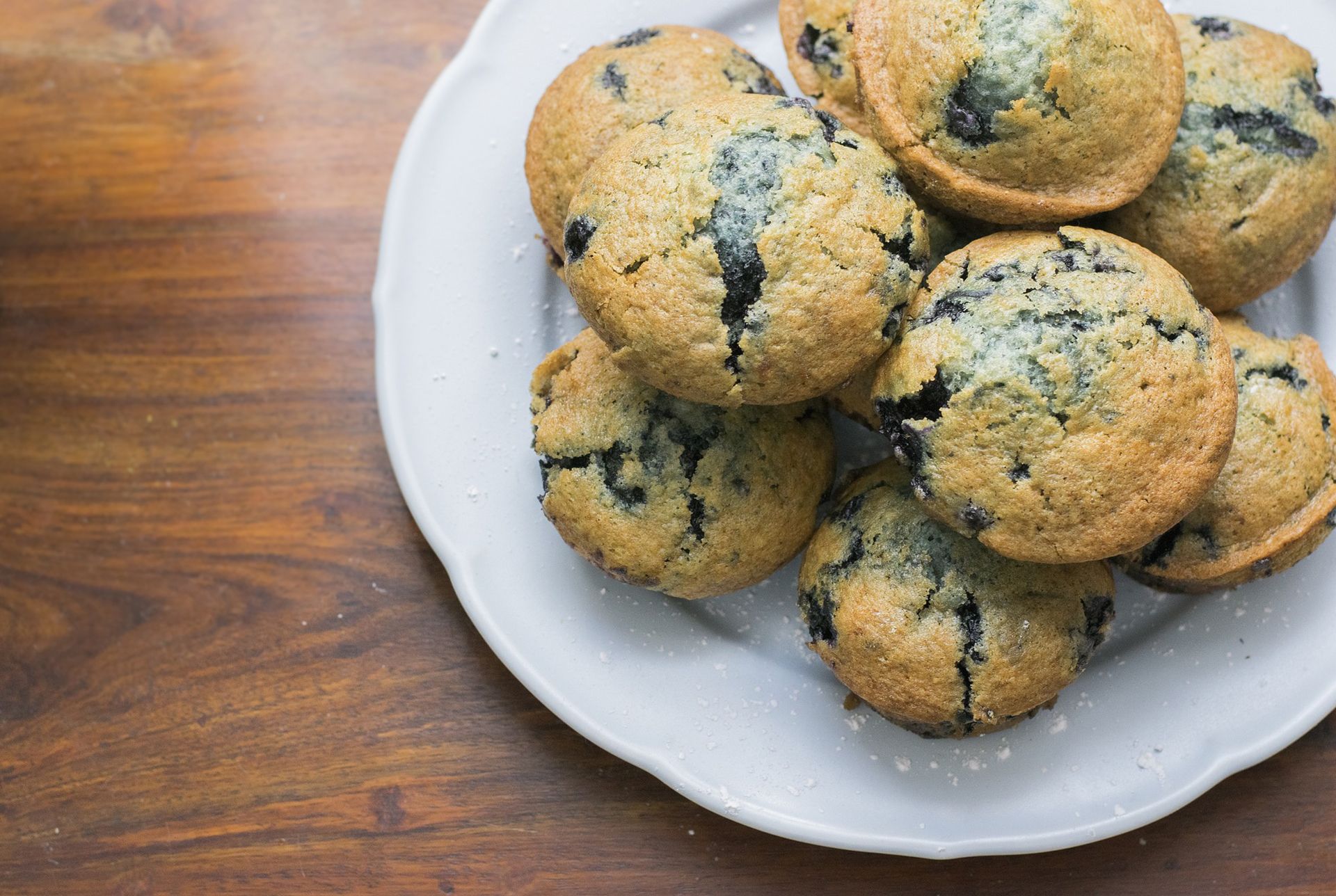 plate full of blueberry muffins sitting on a a table