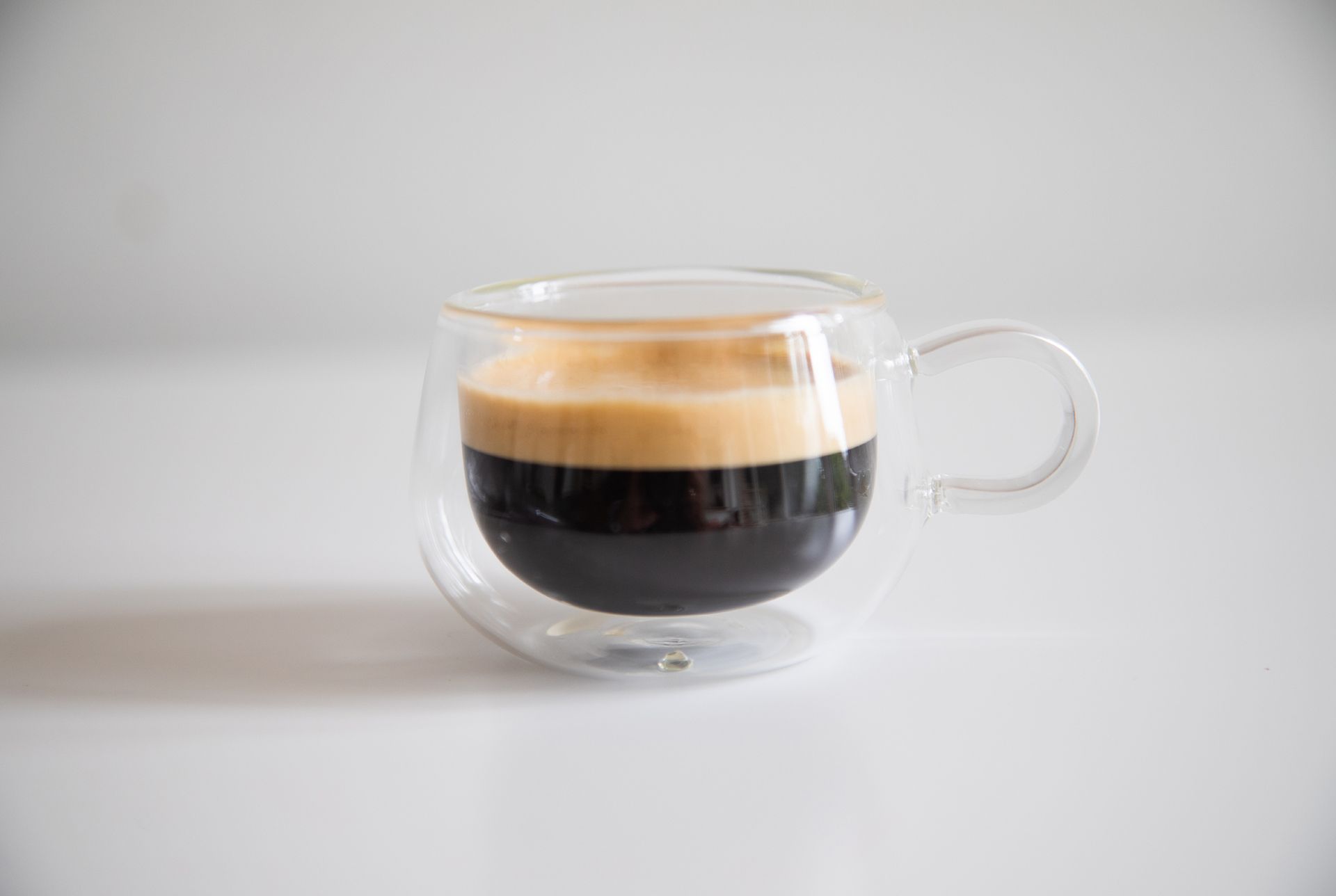 Espresso in a small glass cup on white background