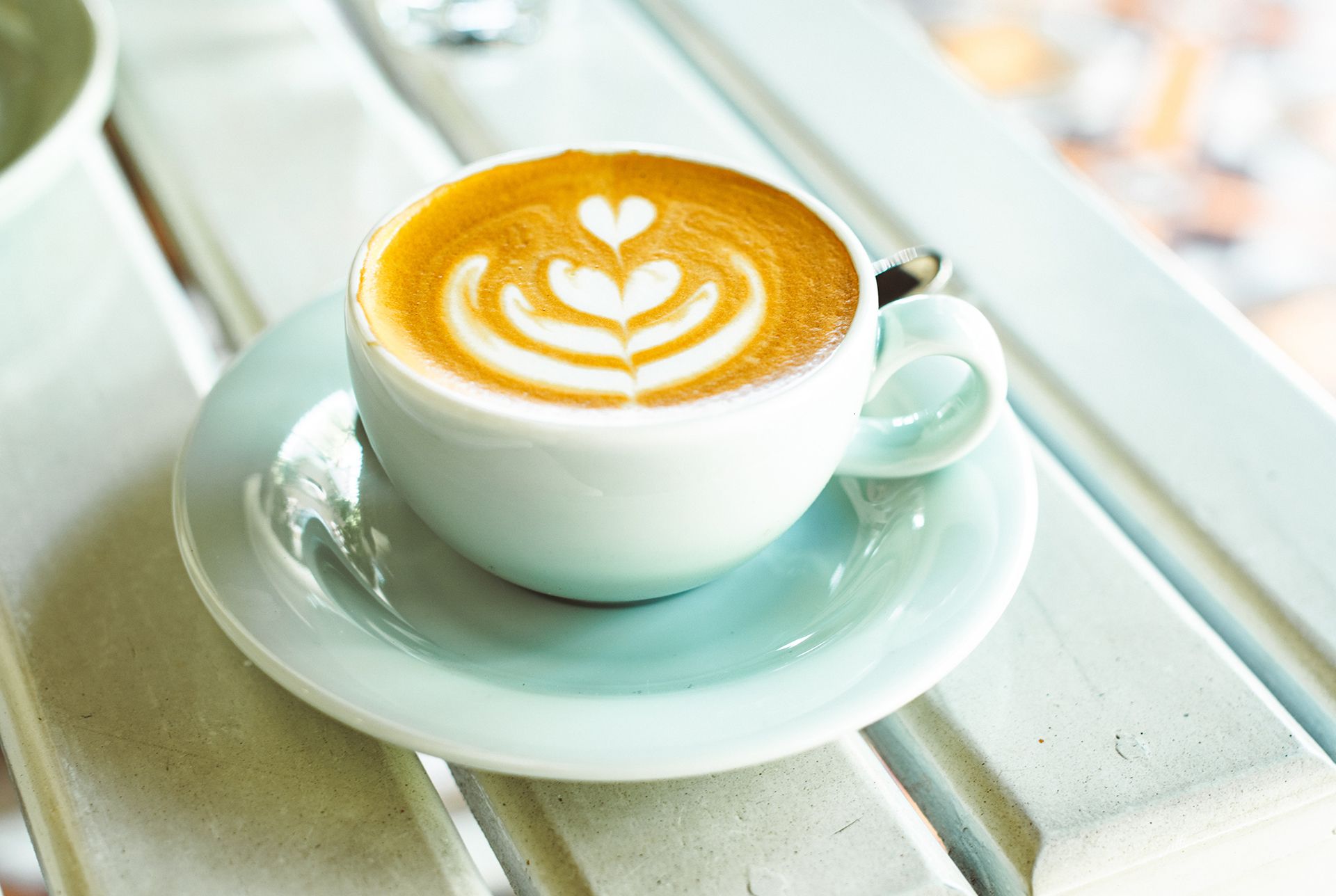 Latte in teal cup on a wooden table